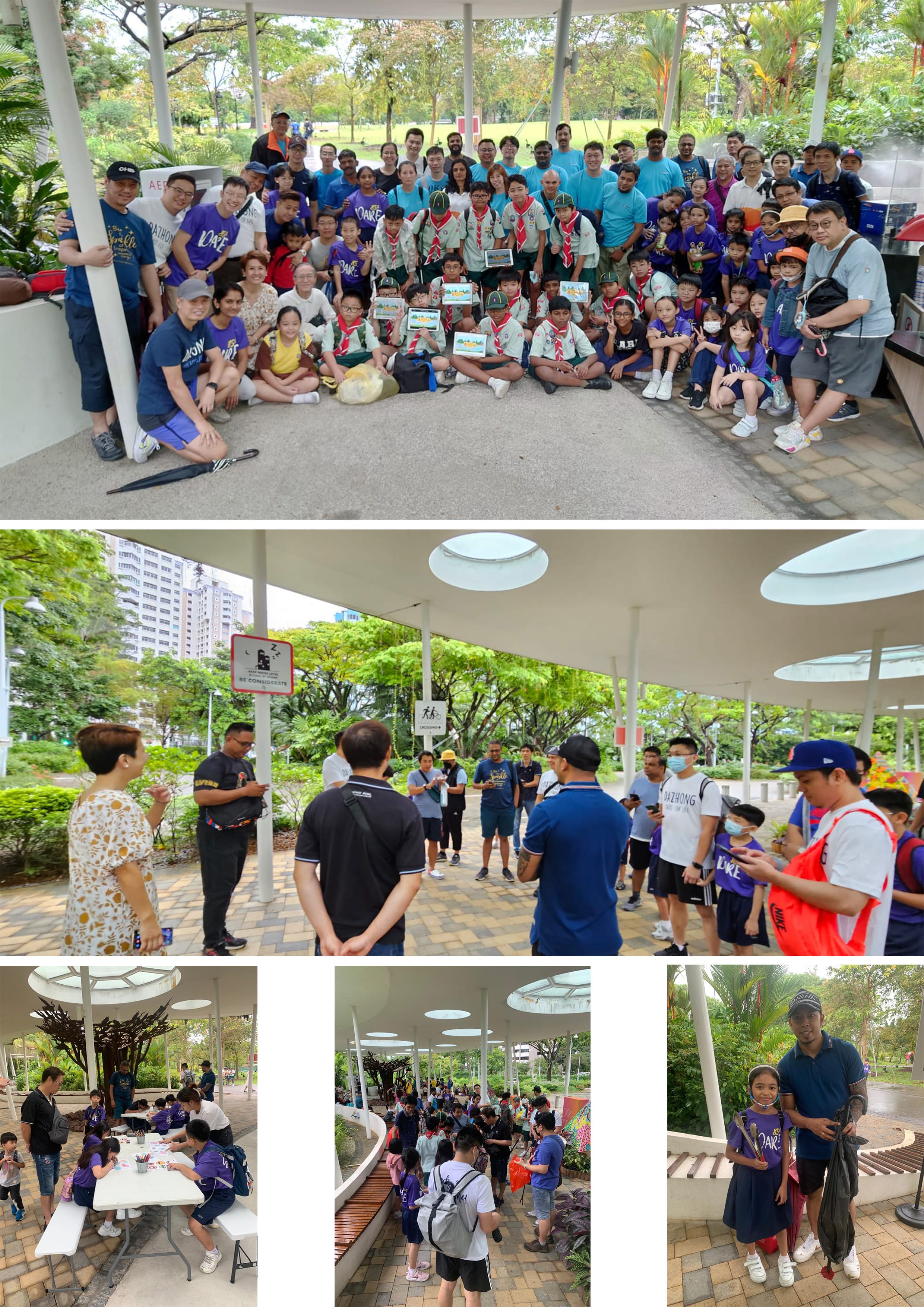 Large group of adults and children including scouts posing and gathering at an outdoor park pavilion.